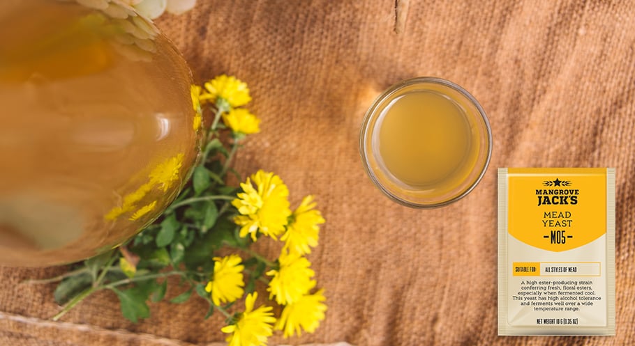 Mead in a glass surrounded by wildflowers and Mangrove Jack's M05 Mead Yeast